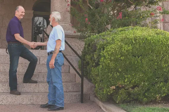 Two white men shaking hands on the steps of Decatur city hall.